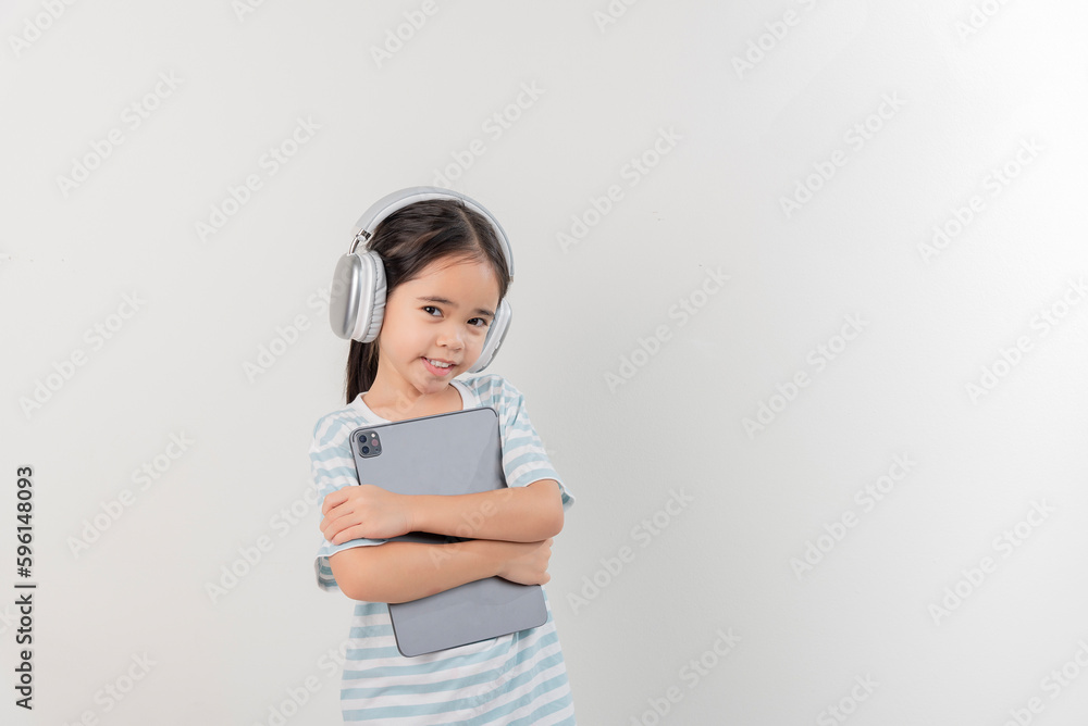 smiling little girl stiiting and holding a tablet with earphone smiling little girl stiiting and holding a tablet with earphone