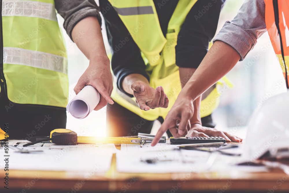 Architect and Engineer working with blueprints for architectural plan, engineer sketching a construction project, green energy concept Architect and Engineer working with blueprints for architectural plan, engineer sketching a construction project, green energy concept