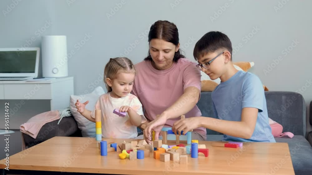 Mom and children build structures from wooden blocks at home.Mothers Day,Family Games,Home Education,Educational Games Mom and children build structures from wooden blocks at home.Mothers Day,Family Games,Home Education,Educational Games