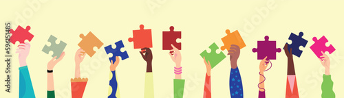 Many hands with pieces of jigsaw puzzle on beige background