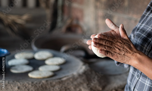 Mexican woman making a corn tortillas in a traditional way