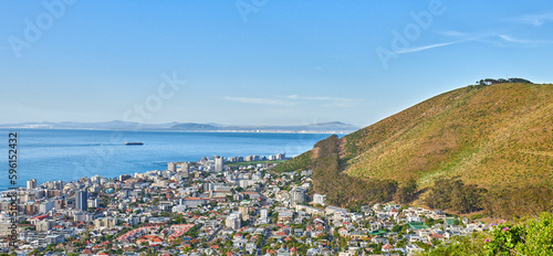 Panoramic shot of a coastal city at the bottom of a hill. The central business district of Cape Town, South Africa, A picturesque horizon showing both land and city, as well as a commercial area