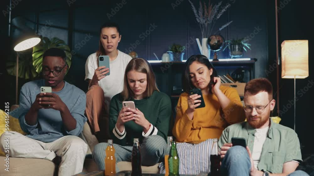 Millenials party. Group of happy multiethnic young students chilling together on couch using smartphones not talking. Millenials party. Group of happy multiethnic young students chilling together on couch using smartphones not talking.