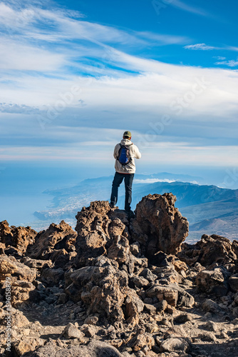 A young man takes photos panoramic view of Teide National Park, Puerto de la Cruz from Volcano El Teide Tenerife, Canary Islands, Spain
