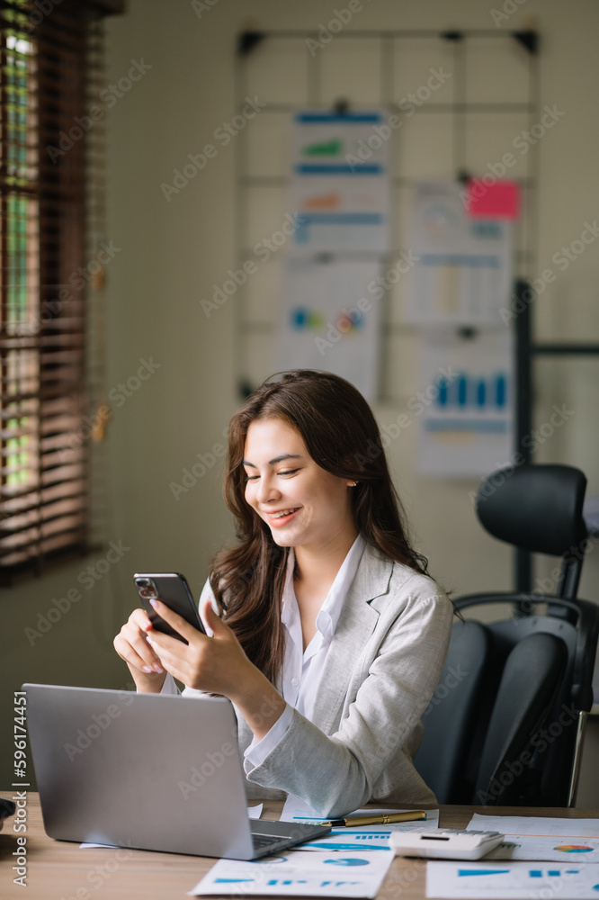 Beautiful Asian business woman typing laptop and tablet Placed at the table at the office Beautiful Asian business woman typing laptop and tablet Placed at the table at the office
