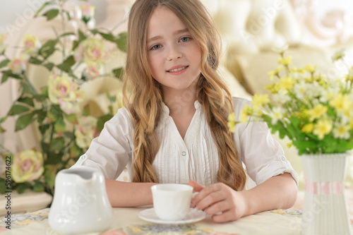 Smiling little girl holding big cup of tea © aletia2011