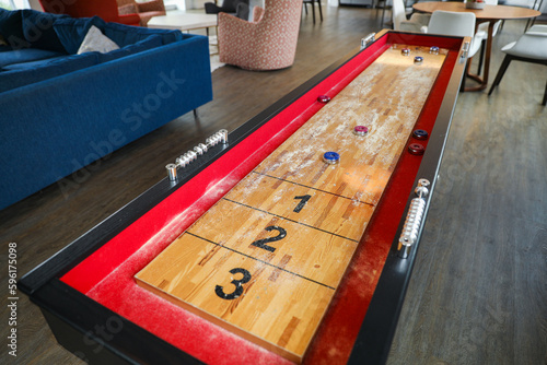 Shuffleboard is a game of precision and strategy, where players slide weighted discs down a narrow court to reach scoring areas. The sport represents the pursuit of accuracy and patience