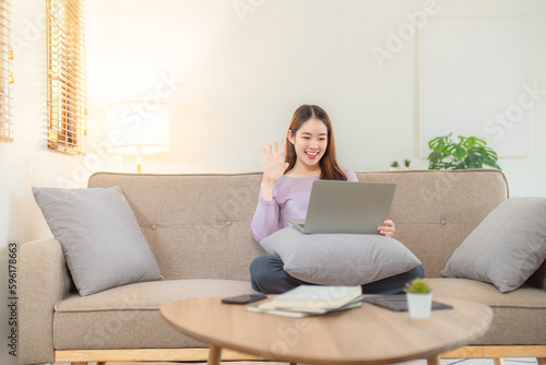 Young woman working on her notebook computer at her home. Work from home concept.
