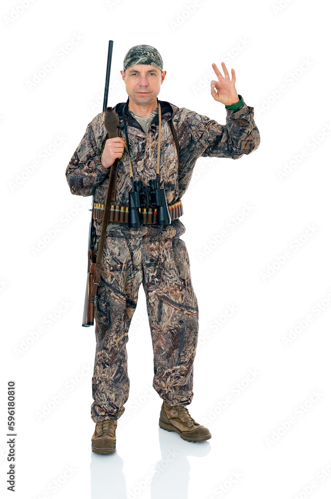 Full lengt portrait of serious duck hunter with a rifle and binoculars show ok okay gesture, isolated on white background. Fifty-year-old man in hunting uniform standing in studio. Full lengt portrait of serious duck hunter with a rifle and binoculars show ok okay gesture, isolated on white background. Fifty-year-old man in hunting uniform standing in studio.