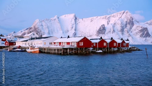 Spectacular winter view of popular tourist destination - Lofoten Islands archipelago. Red houses on the shore of Norwegian sea. Sunrise on Sakrisoy fishing village.  Full HD video (High Definition)..