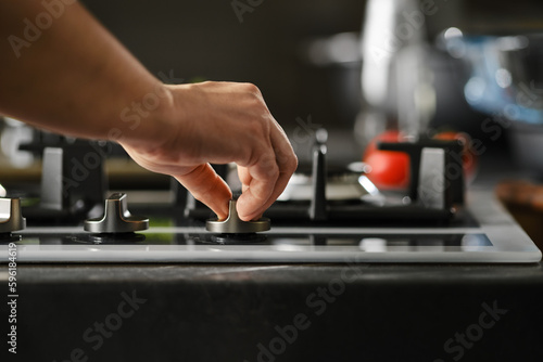 Hand switching on gas on a stove © boomeart
