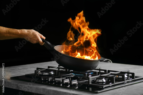 Flambering food ingredients in a frying pan photo