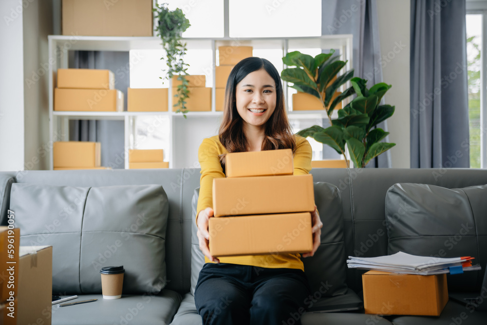 .Young business owner woman prepare parcel box and standing check online orders for deliver to customer on tablet, laptop Shopping Online concept. .Young business owner woman prepare parcel box and standing check online orders for deliver to customer on tablet, laptop Shopping Online concept.