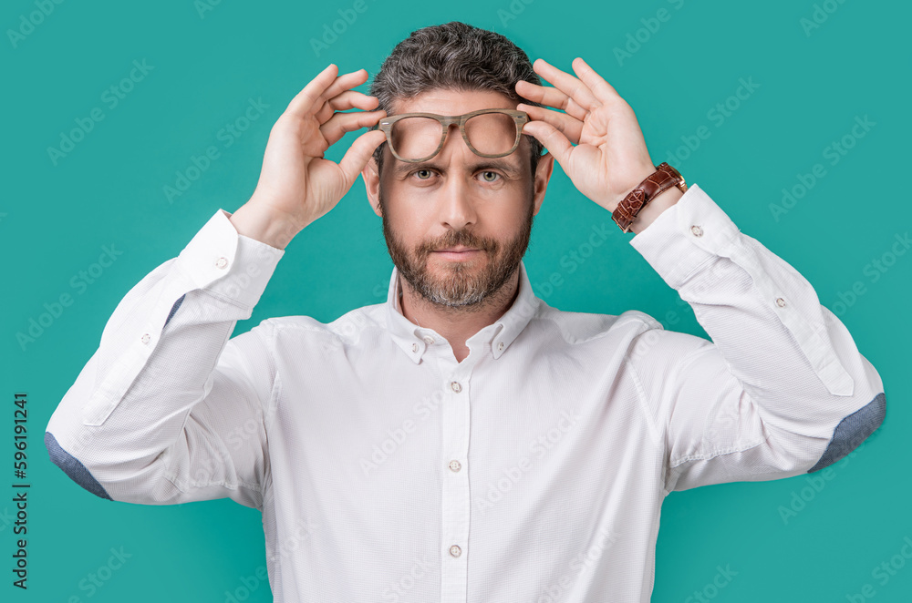 photo of caucasian mature man look in eyewear. man look in eyewear isolated on blue photo of caucasian mature man look in eyewear. man look in eyewear isolated on blue