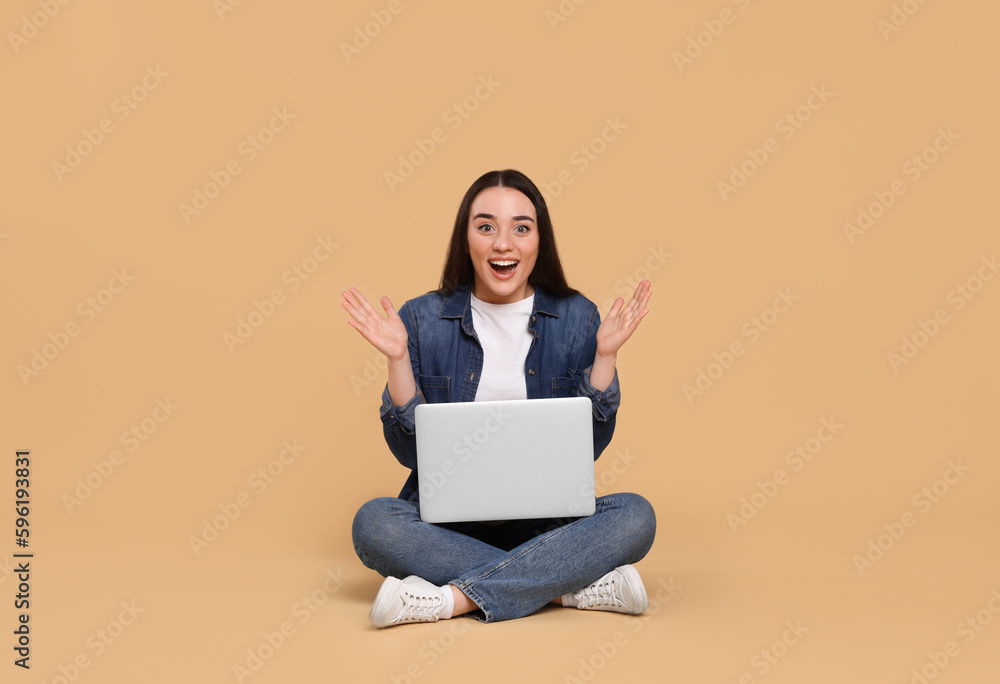 Happy young woman with laptop on beige background Happy young woman with laptop on beige background