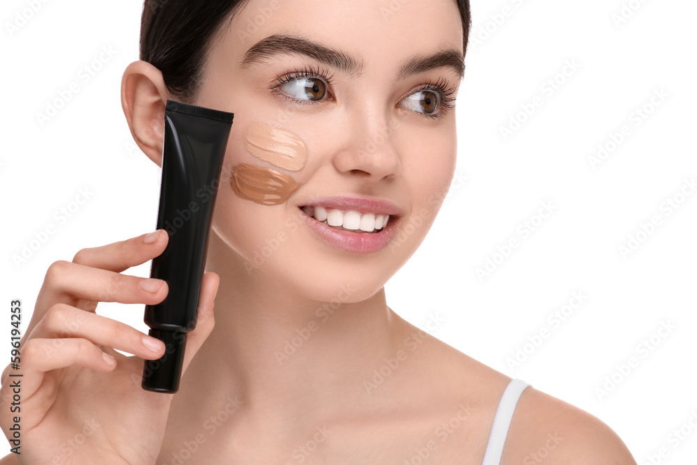 Teenage girl holding tube of foundation on white background Teenage girl holding tube of foundation on white background