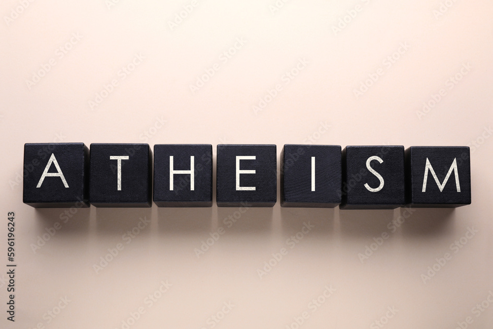 Word Atheism made of black wooden squares with letters on beige background, top view Word Atheism made of black wooden squares with letters on beige background, top view