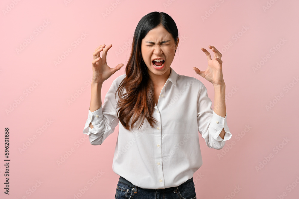 Upset Asian woman having a headache on pink isolated background. Upset Asian woman having a headache on pink isolated background.