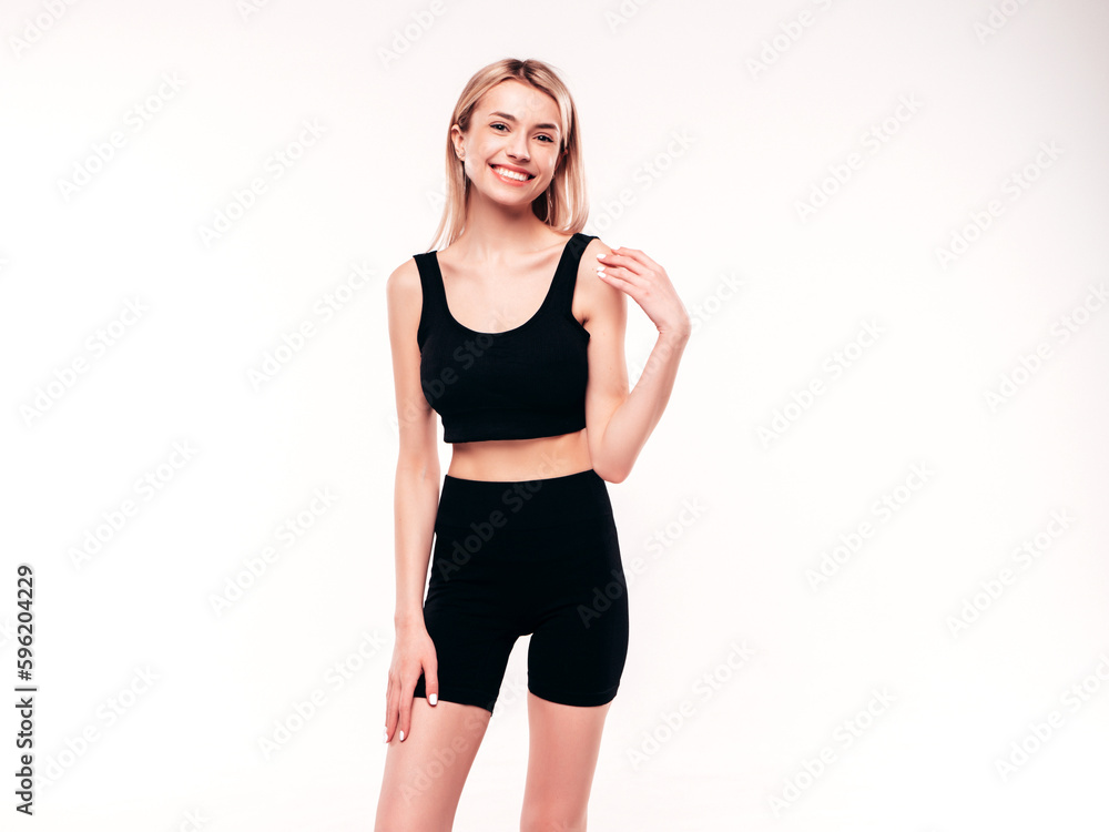 Young beautiful smiling blond female in black cycling shorts clothes. Sexy carefree woman posing on white background in studio. Positive model having fun indoors. Cheerful and happy Young beautiful smiling blond female in black cycling shorts clothes. Sexy carefree woman posing on white background in studio. Positive model having fun indoors. Cheerful and happy