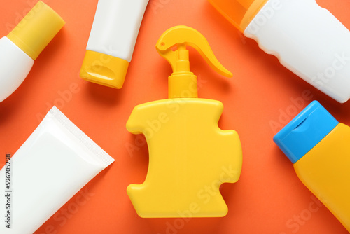 Suntan products on orange background, flat lay