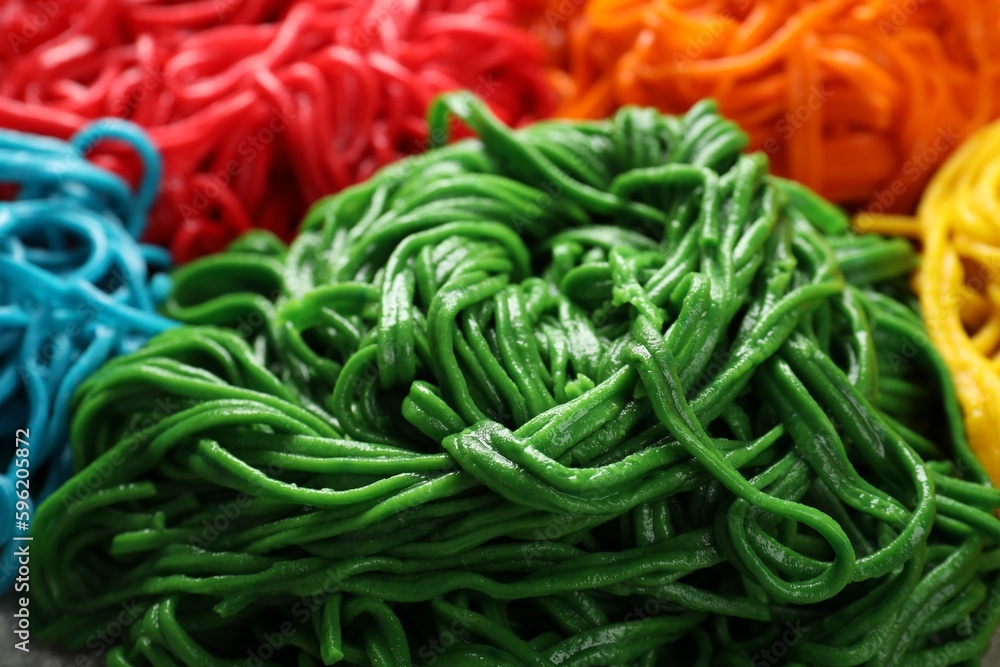 Rolled spaghetti painted with different food colorings as background, closeup Rolled spaghetti painted with different food colorings as background, closeup