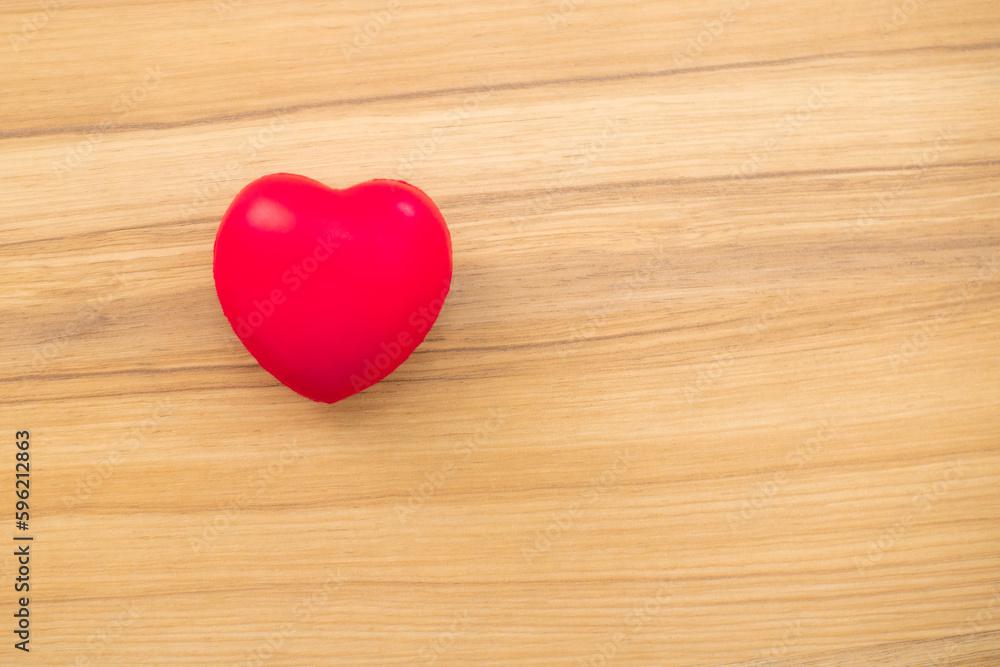 Red heart love shape hand training ball on wooden background: Hospital life insurance concept: World Heart Health Day. doctor's day, world hypertension day Red heart love shape hand training ball on wooden background: Hospital life insurance concept: World Heart Health Day. doctor's day, world hypertension day