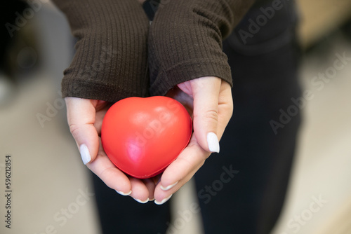 Women's hands holding a red heart, love, healthcare, world organ donation day, mental health,mindfulness, world heart day, world health day.