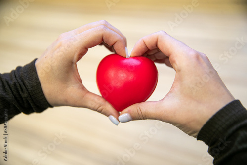 Women's hands holding a red heart, love, healthcare, world organ donation day, mental health,mindfulness, world heart day, world health day.