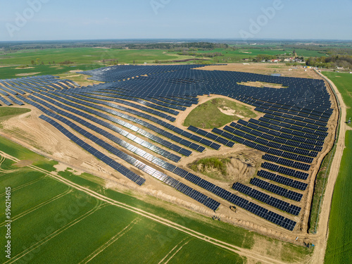 Drone photography of solar farm and green fields, solar power plant in Poland, aerial photo photovoltaic power station on sunny day
