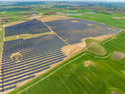 Drone photography of solar farm and green fields, solar power plant in Poland, aerial photo photovoltaic power station on sunny day