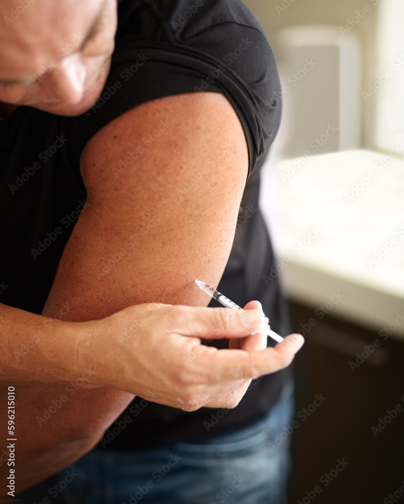 Sports, injection and man with a syringe with steroids in his arm for muscle development. Fitness, testosterone supplement and male body builder injecting with illegal hormone liquid drug with needle Sports, injection and man with a syringe with steroids in his arm for muscle development. Fitness, testosterone supplement and male body builder injecting with illegal hormone liquid drug with needle
