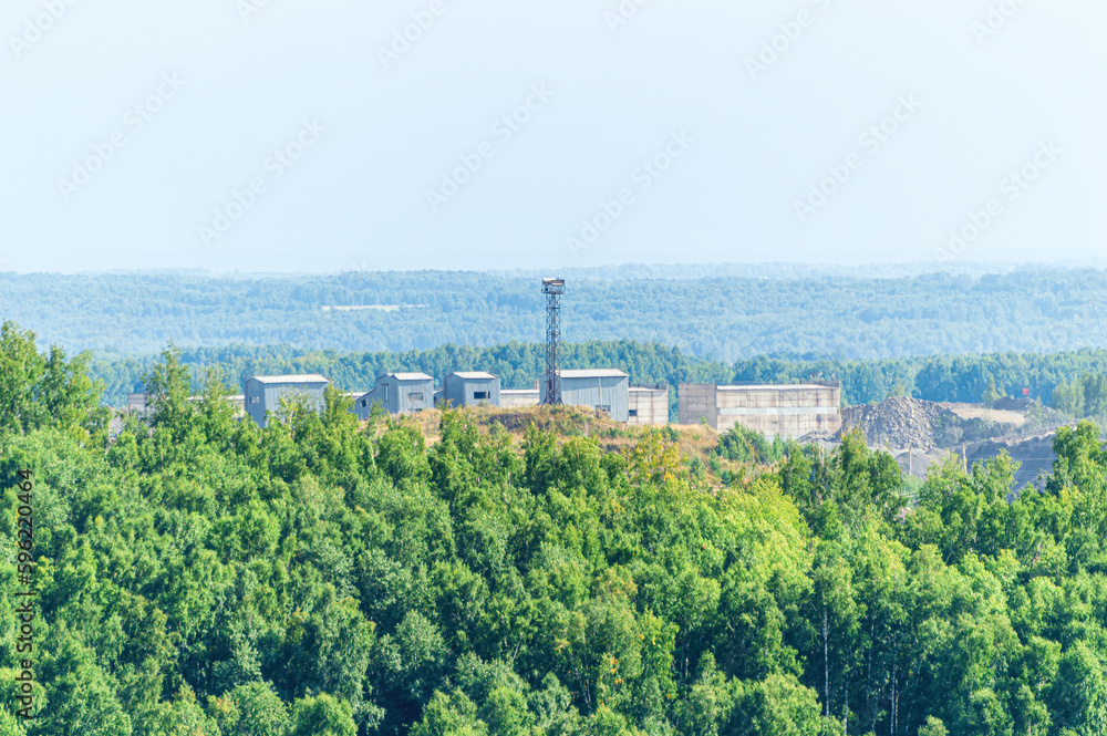 View of Technical Buildings and Small Metallic Tower in the Middle of the Forest