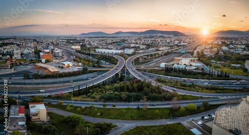 Fototapeta Naklejka Na Ścianę i Meble -  Aerial panoramic view of multilevel highway intersection road as seen in Attiki Odos toll road motorway, Athens, Greece, during golden sunset time