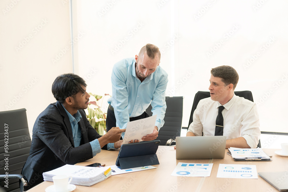Fototapeta premium Investment advisor meeting of three businessmen analyzing company financial report, balance sheet, working with chart papers for stock market. Office