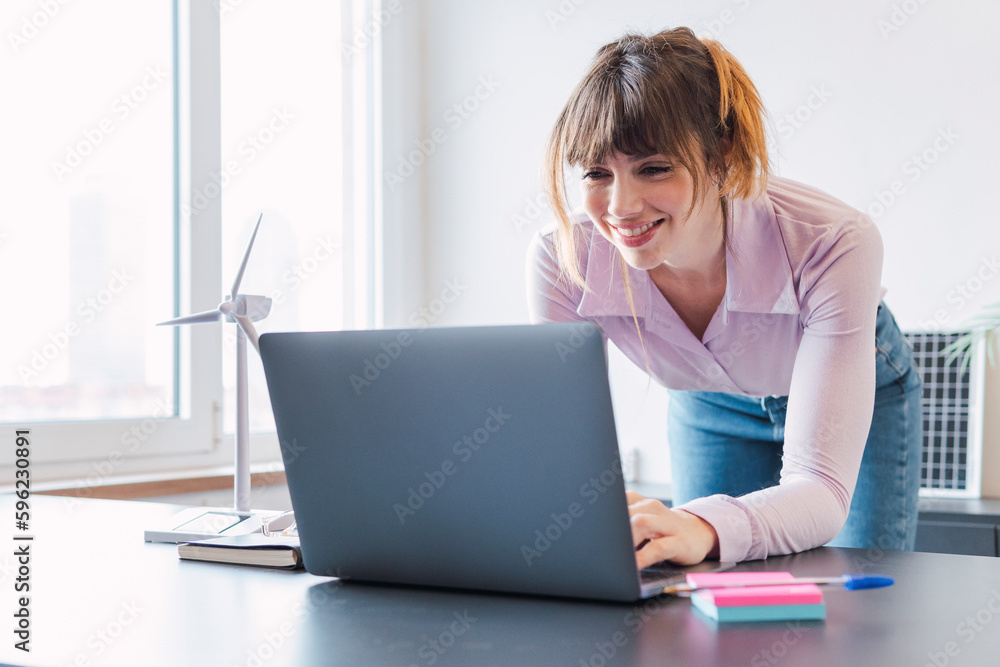 Happy businesswoman working on laptop at desk Happy businesswoman working on laptop at desk