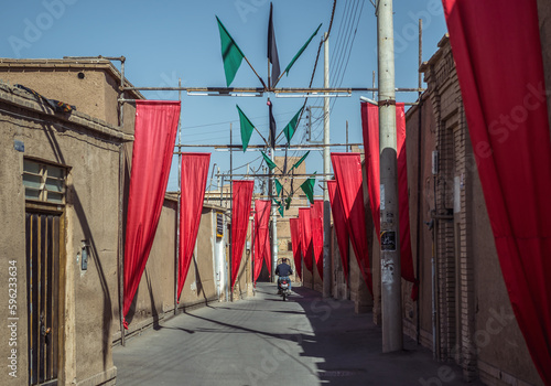 Canvas Print Red flags on a narrow street of Old Town of Kashan city, Iran