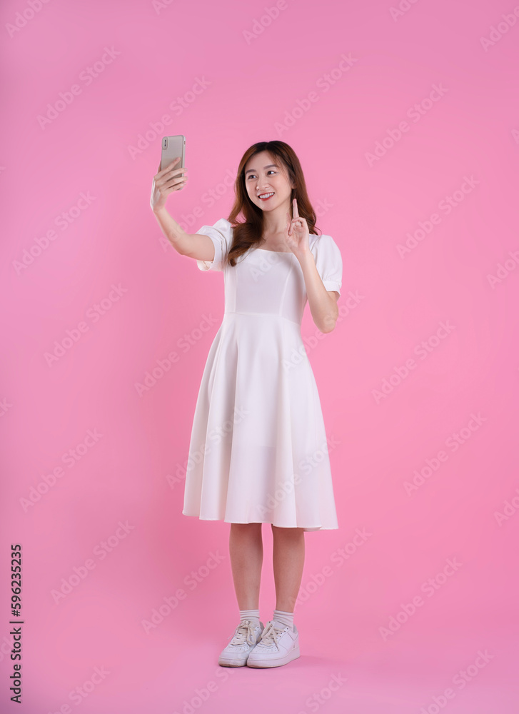 full body image of asian businesswoman using laptop on pink background full body image of asian businesswoman using laptop on pink background