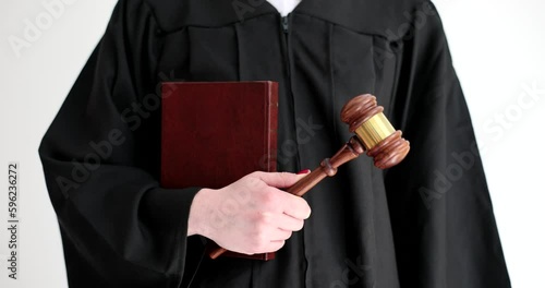 Judge in robe holding penal code book and wooden gavel closeup 4k movie slow motion. Criminal liability lawsuits concept 