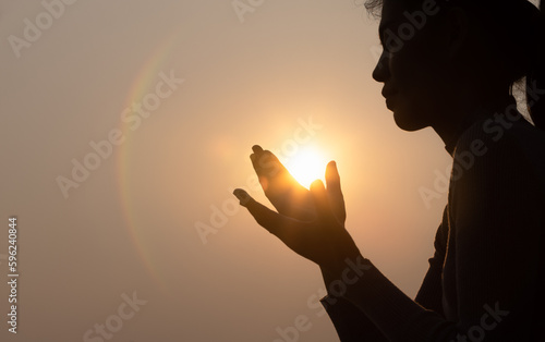 Photography Silhouette of faithful woman praying  at sunset as concept for religion, faith, prayer and spirituality