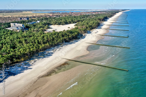 Aerial view looking from the sea over the beach and coastal forest to the village of Rogowo near Kolberg, Poland, with a hotel for vacation photo