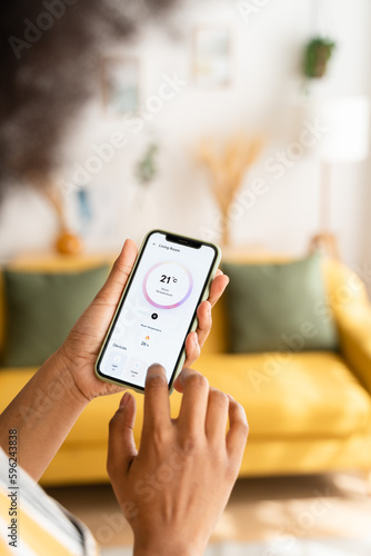 Crop woman using smartphone at home