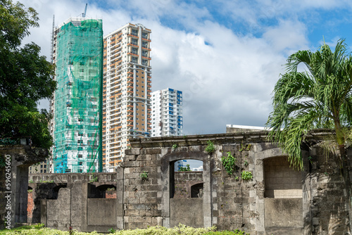 Fort Santiago,ruins with modern buildings in the background,Intramuros,Manila,The Philippines.