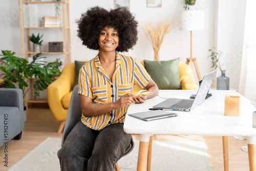 Smiling black woman working on laptop