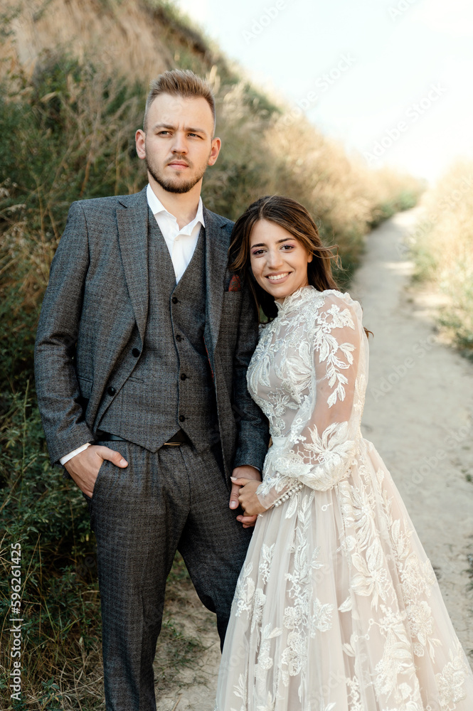portrait of a happy bearded groom hugging a young bride in nature. wedding couple gently hugging. summer wedding day portrait of a happy bearded groom hugging a young bride in nature. wedding couple gently hugging. summer wedding day