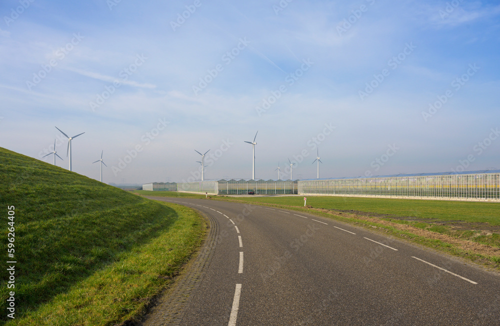 Netherlands, Zeeland, Commercial greenhouses and wind turbines along road Netherlands, Zeeland, Commercial greenhouses and wind turbines along road
