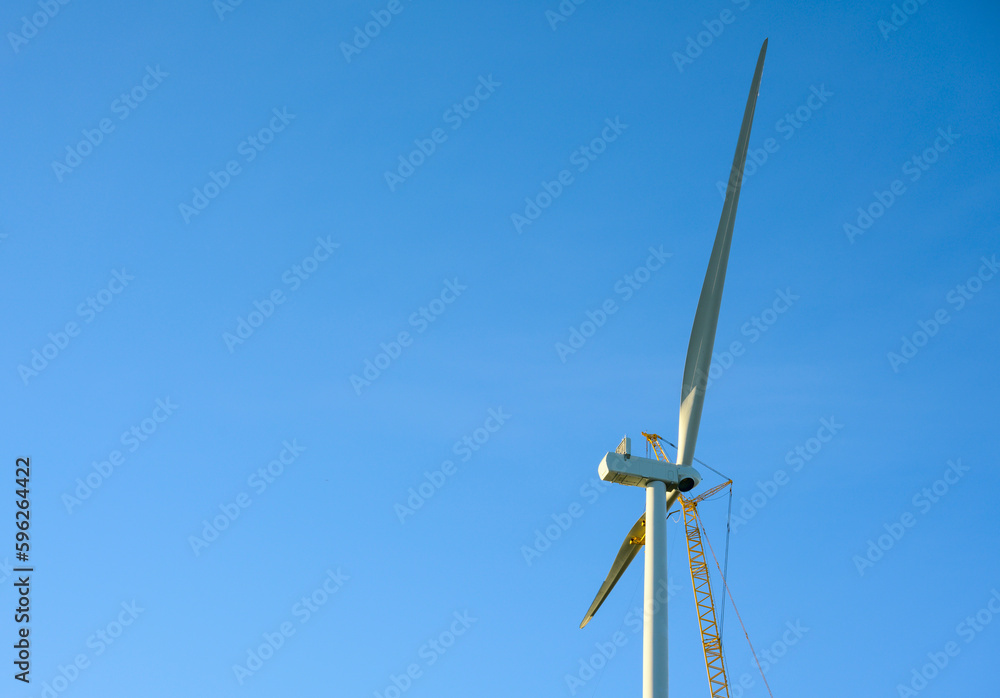 Wind turbine under construction against clear sky Wind turbine under construction against clear sky