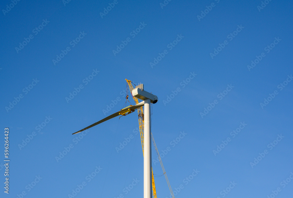 Wind turbine under construction against clear sky Wind turbine under construction against clear sky