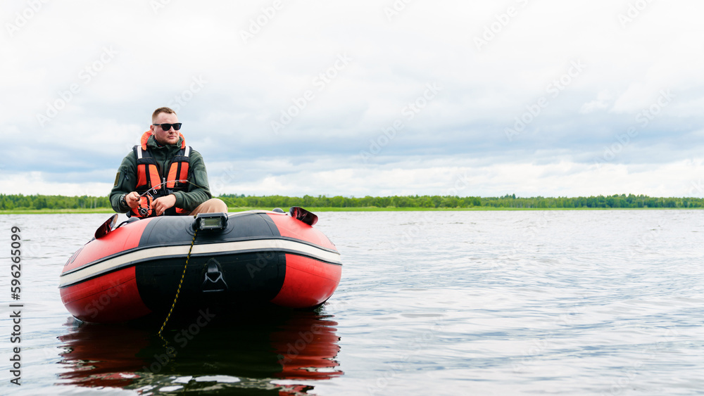 Copy space. Fisherman in an inflatable boat during morning fishing