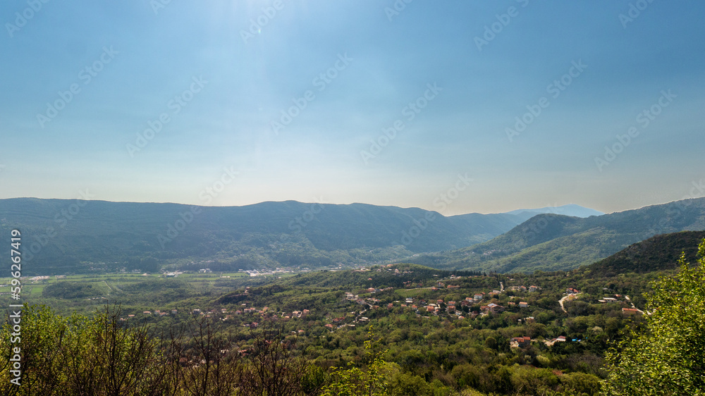 Green valley in mountains under blue sky view from height