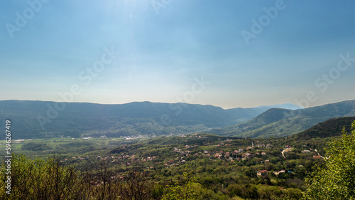 Green valley in mountains under blue sky view from height